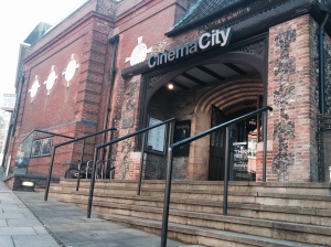 A photo taken outside the front of Cinema City in Norwich. You can see steps leading to the entrance and a ramp to the side. 