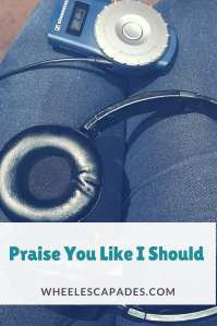 An image to pin. Title text ‘Praise You Like I Should’ is placed over a photograph of a set of headphones on somebody’s lap connected to an audio description box. 