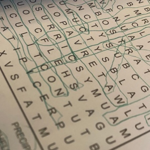Close up section of a wordsearch with lines in green pen. 
